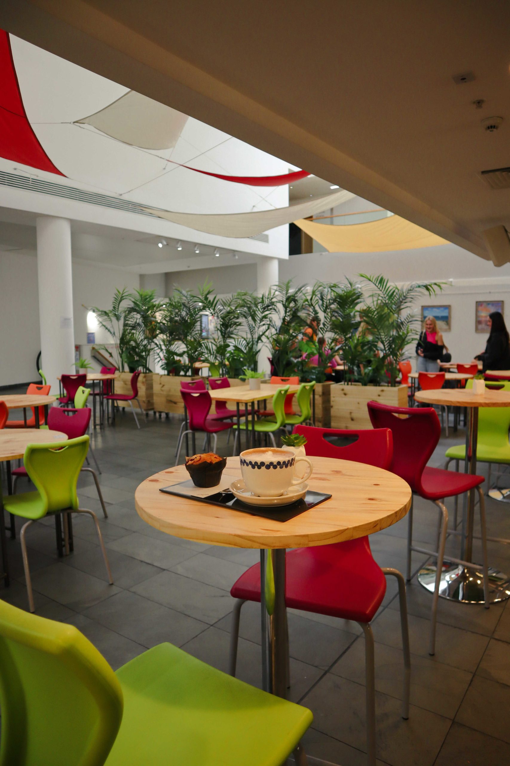 A coffee and muffin sit on a table in artsdepot cafe